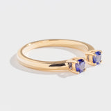 Gold ring with two round blue gemstones set on open ends