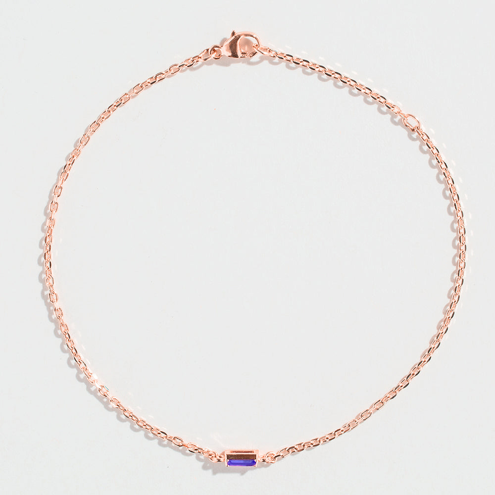 Rose gold bracelet featuring a rectangular blue Tanzanite gemstone at the center.