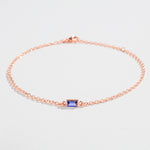 Rose gold bracelet featuring a rectangular blue Tanzanite gemstone at the center.