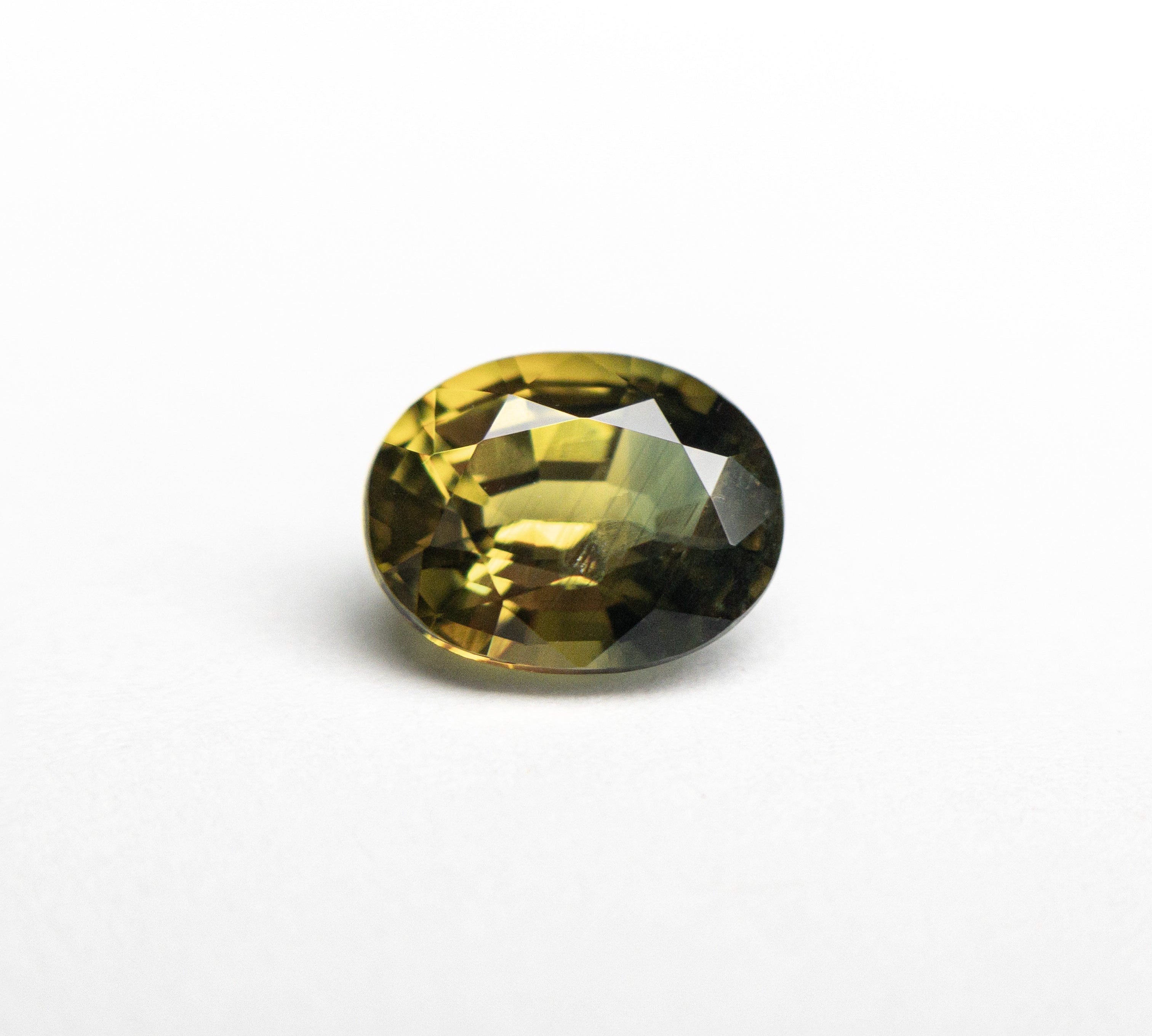 An oval brilliant cut sapphire with parti yellow-green color, originating from Australia.