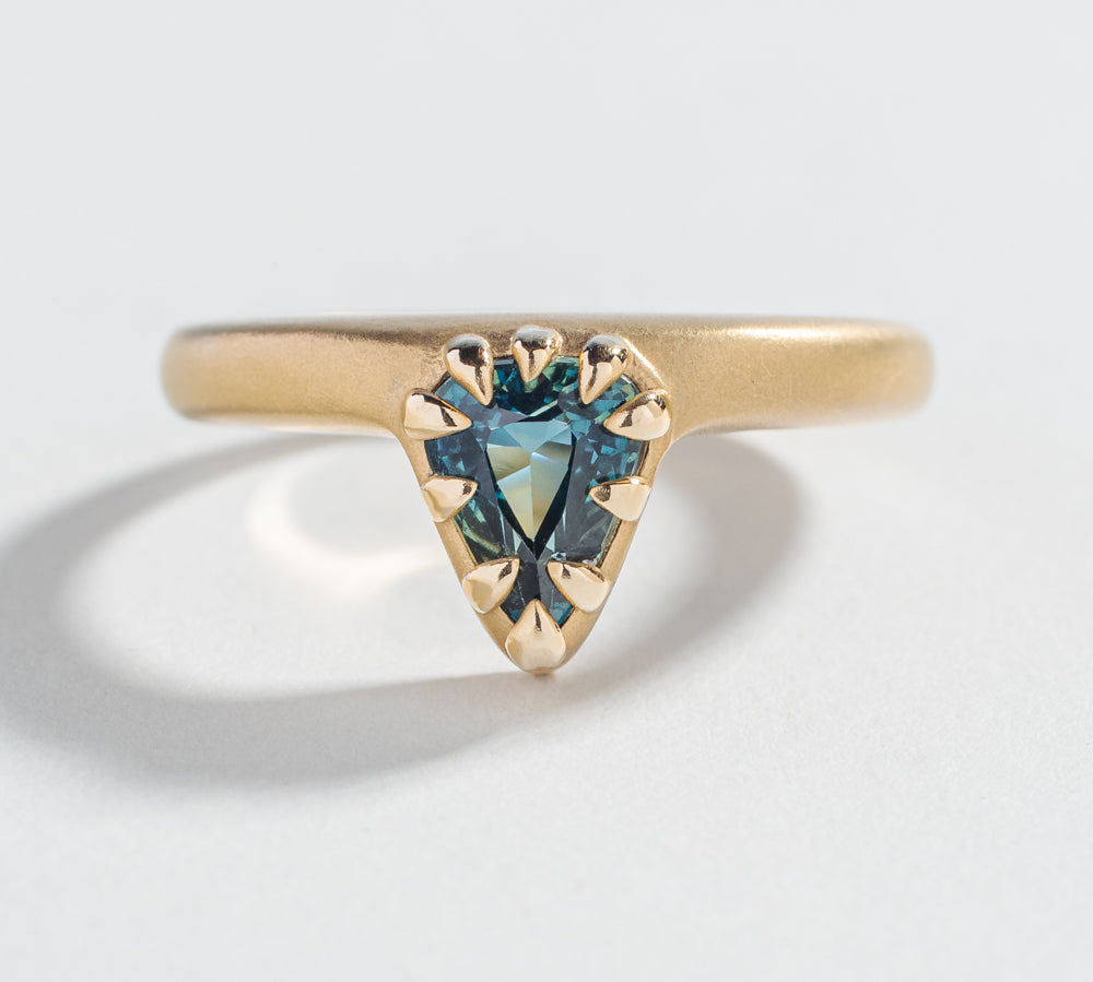 one of a kind engagement ring with blue green teal sapphire pear shape